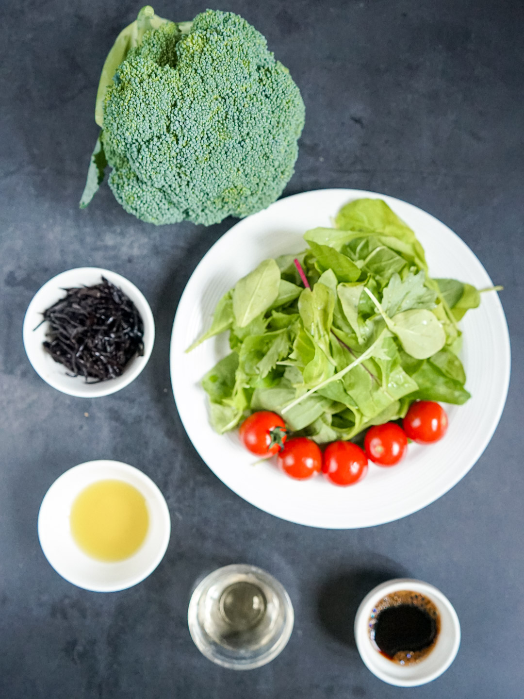 ブロッコリー・ひじき・ミニトマト・葉野菜を並べたサラダ材料写真